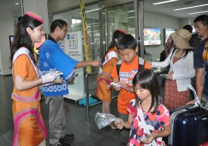 宮古島産のキャンディーやマンゴージュースを振る舞い観光客を歓迎した＝８日、宮古空港