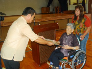 小谷校長（左）が新城さんに卒業証書を伝達授与した＝３日、上野小学校体育館