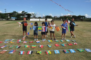 いろいろな国の国旗を作り運動場に掲げた子どもたち＝７日、来間小中グラウンド