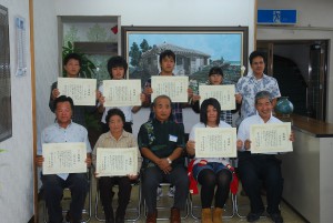 平良社長（前列中央）が感謝状を贈り記念撮影が行われた＝１４日、本社