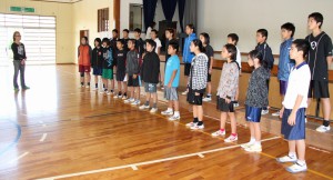 下地さん（左）を前に合唱を披露する児童たち＝２０日、砂川小体育館