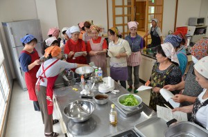 食改員のアドバイスを聞きながら料理に挑戦する参加者たち＝２１日、下地保健福祉センター