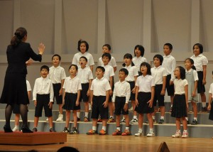 小、中学校合わせて26校の児童生徒が合唱を披露した＝２３日、マティダ市民劇場