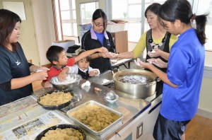 生徒、保護者、教諭らが協力し合って黒糖を活用した甘味作りに挑戦した＝３日、砂川中学校
