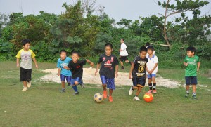 放課後になると元気にボールを追いかける子どもたち。サッカーが大好きだ＝下地小グラウンド