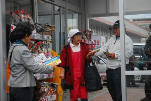 買い物客（中央）に啓発チラシを配布する関係者ら＝12日、サンエーショッピングタウン宮古前