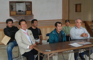 記者会見する佐久田会長（前列中央）と４月から新会長に就任する長崎さん（同右）ら＝16日、旧西原公民館