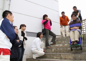 足の不自由な人を専用の器具を使って階段から運び出す方法を学ぶ参加者たち＝16日、平良港ターミナルビル
