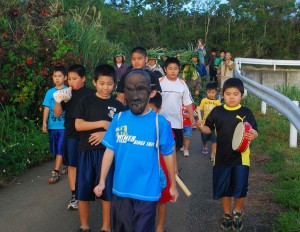 子供パーントゥを先頭に集落内を払い清めた参加者ら＝４日、上野地区野原集落