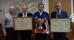 受賞記念のカップを手にする平良さん（右から２人目）＝11日、市役所市長室