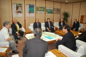 与世田副知事（左）に下地市長（正面左から２人目）が県営広域公園を下地地区と上野地区に分けて２カ所に建設するよう要請した。＝12日、県庁副知事室