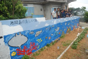 参加者らは、壁画の完成で歓声を上げていた＝28日、池間島の波平三郎さん宅