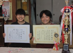 全日本かるた競技鹿児島大会Ｄ級で優勝し賞状を手に笑顔を見せる平良暁子さん（右）と友人の下地沙羅さん＝23日、下地上地・祖母の家