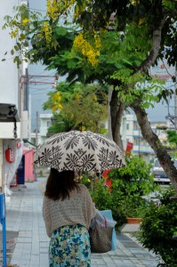 断続的な雨が降り、市内では傘を差して歩く姿が見られた＝14日、下里通り