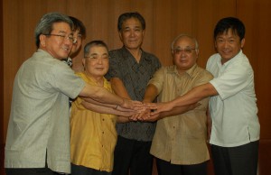 高良副知事（中央）、下地市長（右から2人目）らが結団式＝21日、那覇空港