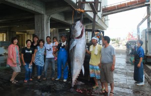 谷口さん（右から３人目）と記念撮影する見学者ら＝17日、宮古島漁協