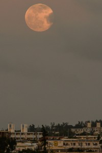 通常の満月よりも大きな月が市街地上空に浮かんだ＝23日午後７時30分すぎ、カママ嶺公園