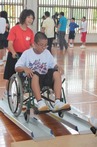 車椅子体験をする生徒たち＝12日、西城中体育館