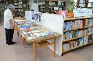 沖縄戦の写真集や書物、パネルなどが展示されている「平和資料展」＝16日、平良図書館北分館
