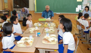 児童たちと一緒に紫いもパンを試食する下地市長（奧）＝９日、北小学校