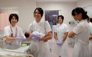 緊張しながら新生児の抱き方などを学ぶ生徒たち＝23日、県立宮古病院