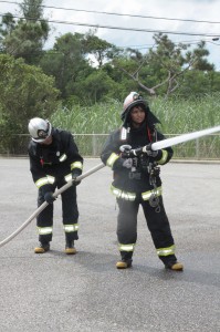 消火活動の訓練を体験する北原さん＝11日、市消防本部
