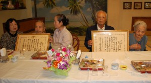家族、親戚が一堂に会して狩俣恵茂さん（左から２人目）と川満マツカマさん（右）の百歳を祝う合同祝賀会を盛大に催した＝28日、レストランのむら
