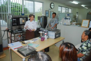 宮里さんが紅イモを活用しスチームコンベクションオーブン（左）と真空包装機（右）について説明した＝23日、ホシザキ沖縄宮古営業所