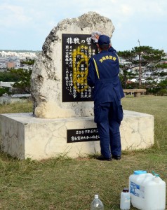 宮古島署の署員が黄色い塗料が吹きかけられた「九条の碑」の鑑識活動を行った＝26日、カママ嶺公園