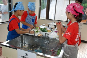 チームワークを発揮し料理作りを頑張る子どもたち＝16日、城辺農村環境改善センター