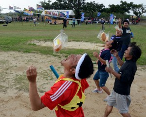 パン食いリレーで競う参加者たち＝23日、佐良浜中グラウンド