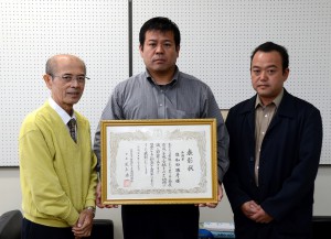 佐和田さん（中央）が川満教育長（左）に日本ＰＴＡ全国協議会会長特別表彰の受賞を報告した＝２日、市役所城辺庁舎
