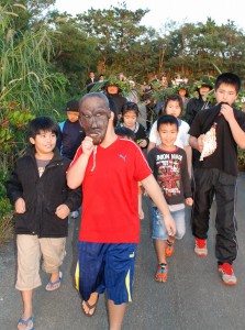 子供パーントゥを先頭に集落内を払い清めた参加者ら＝３０日、上野地区野原集落