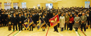 各学年の優勝旗と記念撮影する関係者と生徒たち＝14日、平良中学校の体育館
