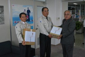 下地市長（右）が砂川専務（中央）らにドリンクを贈った＝２０日、沖縄製糖宮古工場