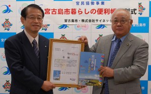 サイネックスの村田社長（左）と下地市長が「暮らしの便利帳」の発刊式を行った＝１１日、市平良庁舎