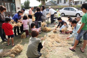 ススキを使ったほうきを作る参加者たち＝３０日、東川根自治会館