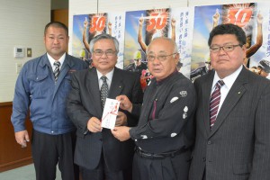松田取締役営業部長（左から２人目）が大会長の下地市長に贈った＝２８日、市役所平良庁舎