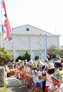 園児たちがみんなで鯉のぼりを上げる掲揚式＝２２日、市役所平良庁舎玄関前