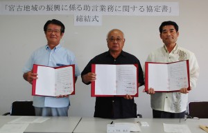 （写真左から）譜久山理事長、下地市長、伊良皆村長が、おのおの協定書に署名し、助言業務の締結を行った＝２６日、沖縄公庫宮古支店