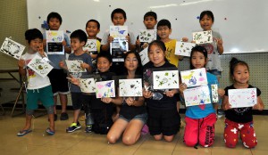 自慢の海藻押し葉作品を手に笑顔を見せる子供たち＝１７日、宮古島市総合博物館
