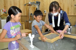 苧麻紙をすく子供たち。うちわづくりに挑戦した＝２６日、市伝統工芸品センター