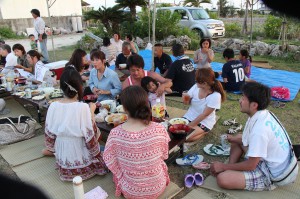伝統料理を味わいながら交流を深める参加者たち＝２５日、城辺友利