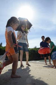 強い日差しの下、砂浜で遊ぶ家族連れ＝5日、パイナガマビーチ