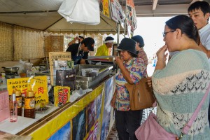 津山市の物産展で試食しながら買い求める人が多く見られた＝２９日、サンエーショッピングタウン宮古衣料館前
