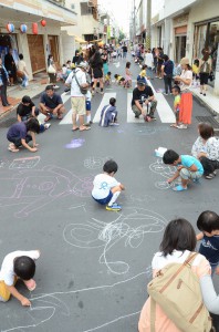 子供たちが道路いっぱいに思い思いの絵を描いた路上ペイント＝１３日、西里通り