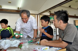 参加親子にエコカーの作り方を指導する清水洋一さん（右から３人目）＝２７日、市中央公民館