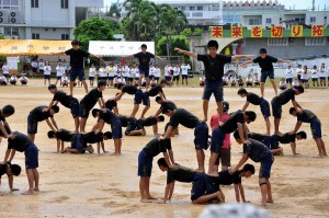 雨でグラウンドコンディションが不良の中、息の合った組体操を披露する生徒たち（写真は平良中の運動会）＝１４日、平良中グラウンド