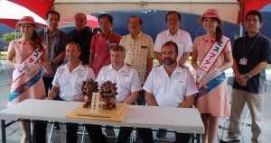 歓迎セレモニーが行われ、プレチャシア船長（前列右）らに陶器のシーサーなどの記念品が贈られた＝１３日、平良港