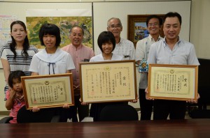 立津さん（手前左）と大濱さん（手前中央）が喜びの報告を行った＝２５日、市役所城辺庁舎